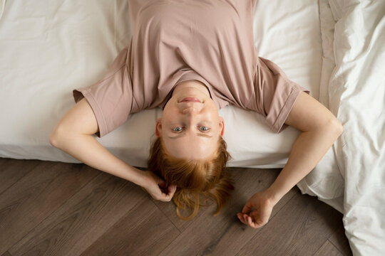 Smiling Young Woman Lying On Bed