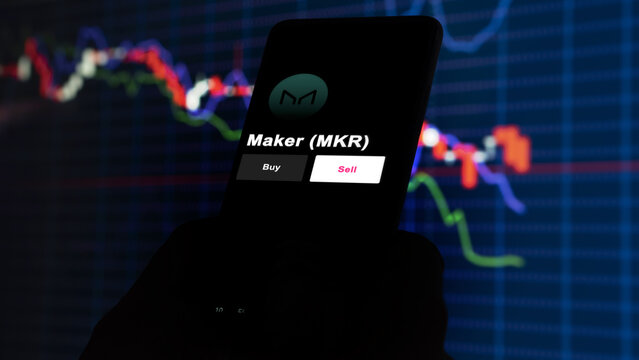 September 13th 2022, London UK. An investor's analyzing the Maker (MKR) coin on screen. A phone shows the crypto's prices to invest