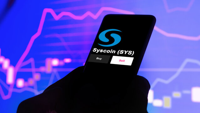September 13th 2022, London UK. An investor's analyzing the Syscoin (SYS) coin on screen. A phone shows the ETF's prices to invest