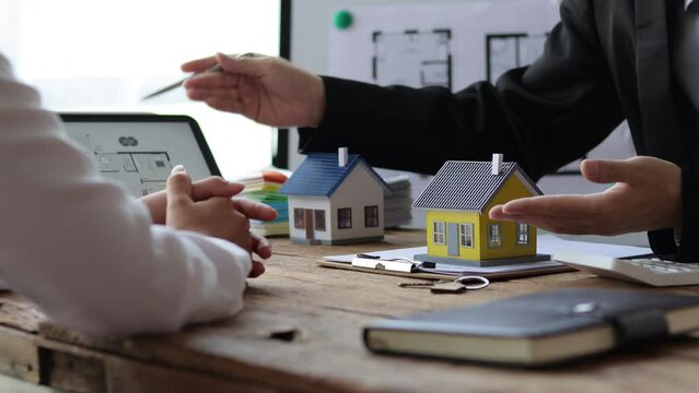 The businessman consulted the design of the housing estate and discussed the terms of the real estate purchase agreement.