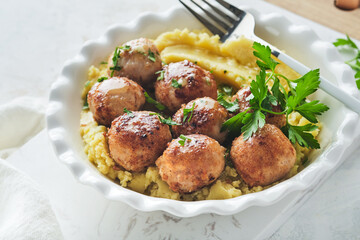 Swedish meatballs in cream sauce, potatoes and lingonberry sauce in bowl on slate, stone or concrete backgrounds. Swedish cuisine. Delicious creamy mashed potatoes. Top view.