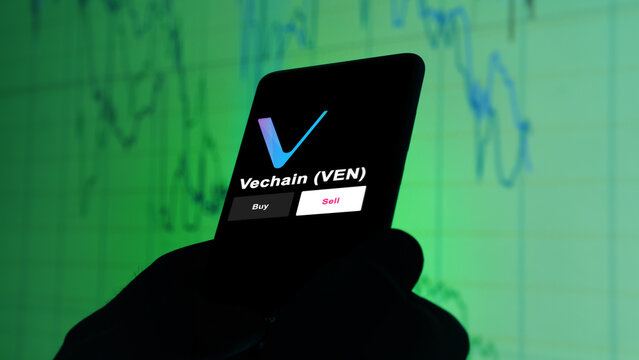 Vechain VEN coin on screen. A phone shows the $VEN coin prices to invest, an investor's analyzing.