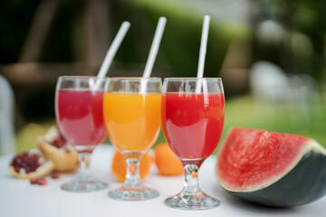 Orange juice, pomegranate juice and watermelon juice on the natural background