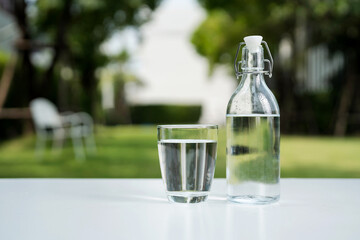 A glass of clean drinking water and a water bottle.