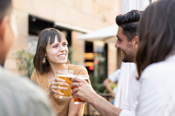 Friends drinking beer at brewery pub garden - Genuine friendship life style concept with guys and girls enjoying happy hour food together at open air bar dehor - Warm vivid filter