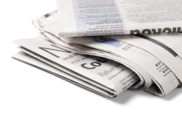 Pile of newspapers on blurred background, close up