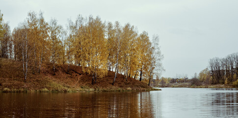 Autumn landscape with birch trees and forest river