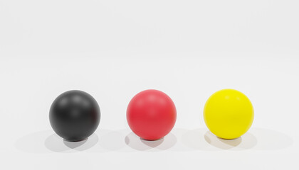3d-rendering of three balls with the colours black, red and yellow as a symbol for the colours of the german national flag in front of a white background