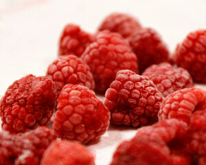 freshly rinsed raspberries on a white background
