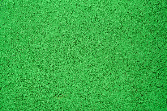 Background of green concrete wall. Decorative embossed concrete and glue plaster. Green plastered wall. Plaster textured background. Blurred photo.