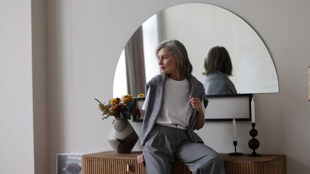 half-length portrait of fifty year old stylish woman in home interior