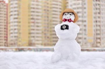 Snowman photographer at the winter city