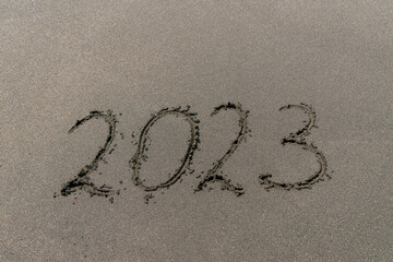 Close-up of the numbers 2023 on the sand, symbols of the new year