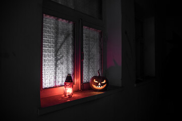 Scary Halloween pumpkin in the mystical house window at night or halloween pumpkin in night on room...