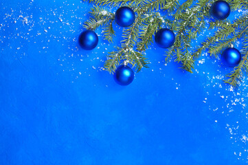 Blue background with decorated Christmas tree branches