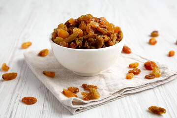Organic Dried Raisins in a White Bowl, side view. Close-up.