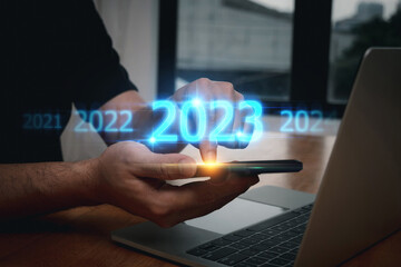 2023. poeple hand using mobile smart phone with virtual screen on desk at home, finance, business...