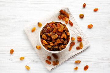 Organic Dried Raisins in a White Bowl, top view. Overhead, from above, flat lay.