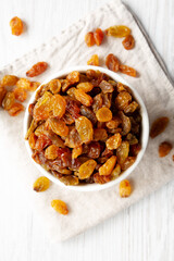 Organic Dried Raisins in a White Bowl, top view. Overhead, from above, flat lay.