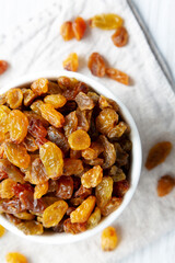 Organic Dried Raisins in a White Bowl, top view. Overhead, from above, flat lay.