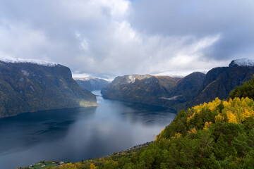 Fototapeta na wymiar View of Aurlandsfjord and the surrounding snow mountains from the Stegastein viewing platform in fall. Aurlandsfjord is a fjord in Vestland county, Norway.