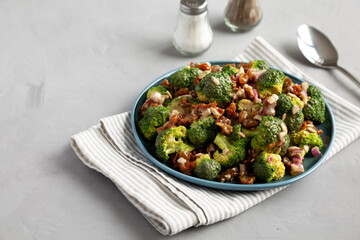 Homemade Broccoli Bacon Salad on a Plate on a gray background, side view. Copy space.