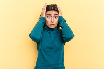 Young Indian woman isolated on yellow background being shocked, she has remembered important...