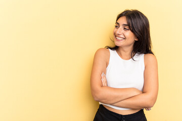 Obraz premium Young Indian woman isolated on yellow background smiling confident with crossed arms.