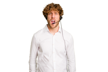 Telemarketer man working with a headset isolated on green chroma background screaming very angry and aggressive.