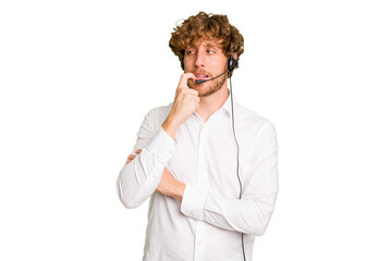 Telemarketer man working with a headset isolated on green chroma background relaxed thinking about...