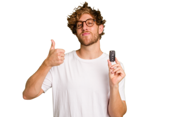 Young caucasian man holding car keys isolated on white background smiling and raising thumb up