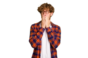 Young caucasian man isolated on green chroma background thoughtful looking to a copy space covering mouth with hand.