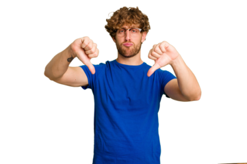 Young caucasian man isolated on green chroma background showing a dislike gesture, thumbs down. Disagreement concept.