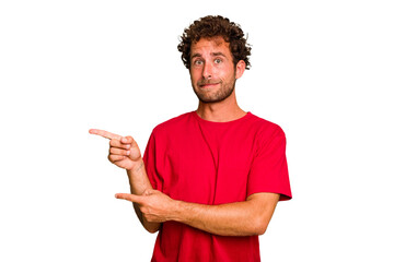 Young caucasian curly hair man isolated Young caucasian man with curly hair isolated shocked pointing with index fingers to a copy space.