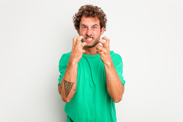 Young caucasian curly hair man isolated on white background upset screaming with tense hands.