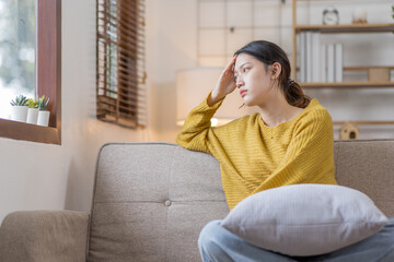 Depressed young Asian woman sitting on floor at home, Frustrated confused Sad female feels unhappy problem in personal life quarrel breakup with boyfriend or unexpected pregnancy concept