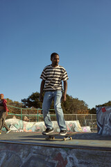 Portrait of young non-binary doing flip tricks on skateboard at skatepark © Sheilby Macena