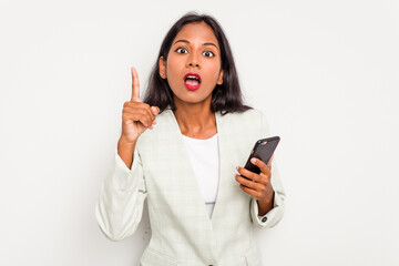 Young business Indian woman holding a mobile phone isolated on white background having an idea,...
