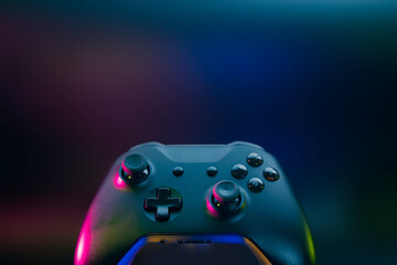 gamer playing the online game with joystick controller in neon glow dark cyberpunk room, gaming and e-sports challenge tournament streaming, streamer with analog device in living house © issaronow