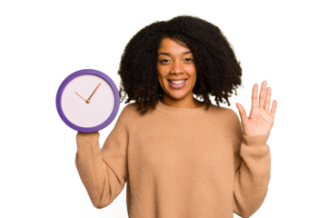 Young African American holding a clock isolated smiling cheerful showing number five with fingers.
