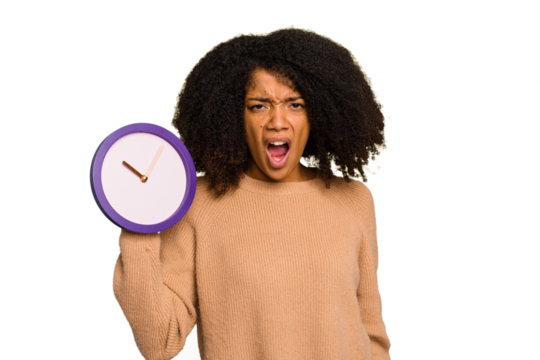 Young African American holding a clock isolated screaming very angry and aggressive. - Powered by Adobe