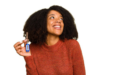 Young African american woman holding home keys isolated dreaming of achieving goals and purposes