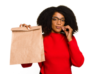 Young African american woman holding take away food isolated with fingers on lips keeping a secret.