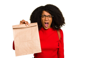 Young African american woman holding take away food isolated screaming very angry and aggressive.