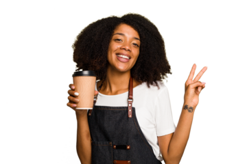 Young african american woman barista holding a takeaway coffee joyful and carefree showing a peace symbol with fingers.