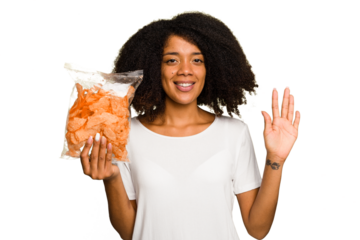 Young African american man holding crips isolated smiling cheerful showing number five with fingers.