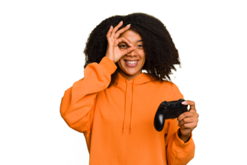 Young African American woman holding a game controller isolated excited keeping ok gesture on eye.