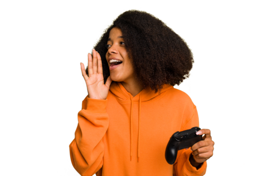 Young African American woman holding a game controller isolated shouting and holding palm near opened mouth.