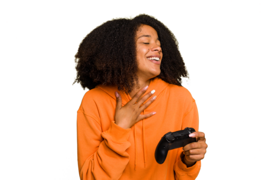 Young African American woman holding a game controller isolated laughs out loudly keeping hand on chest.