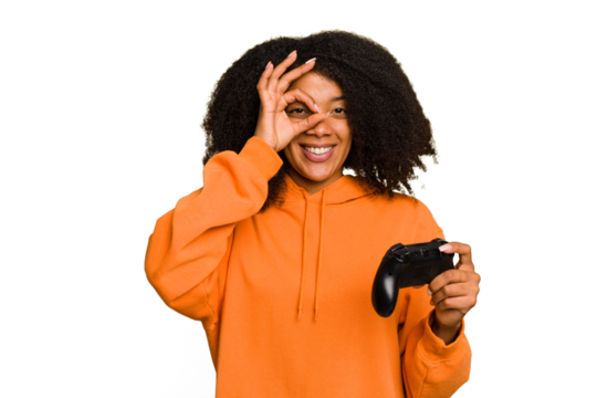 Young African American woman holding a game controller isolated excited keeping ok gesture on eye.